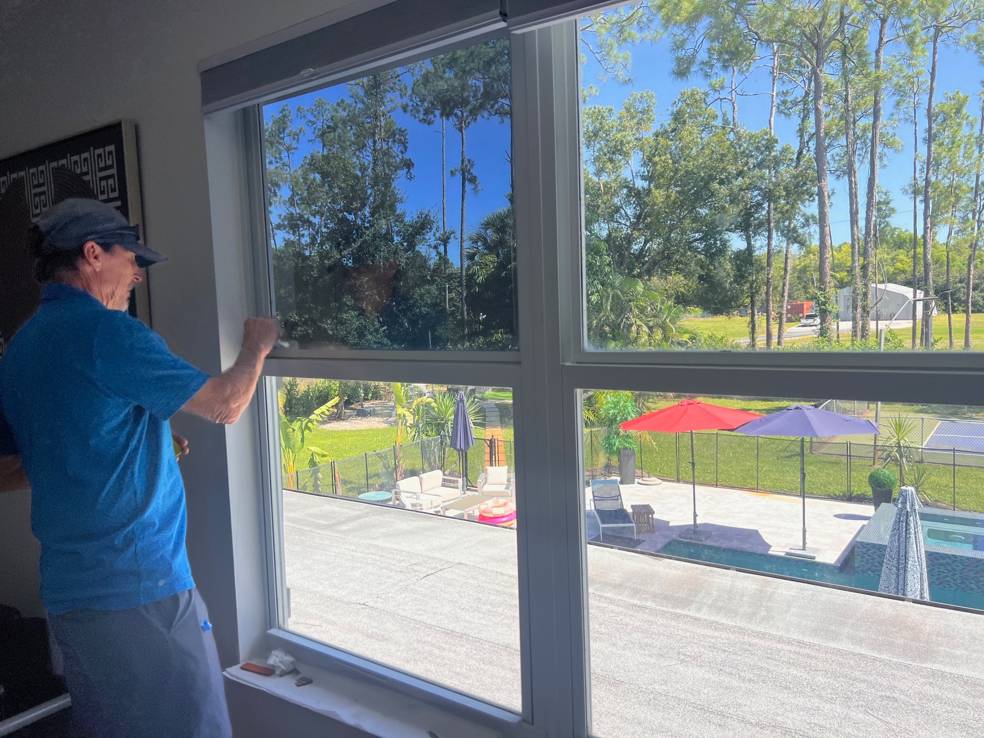 Installer working on residential solar-control window film in Southwest Florida