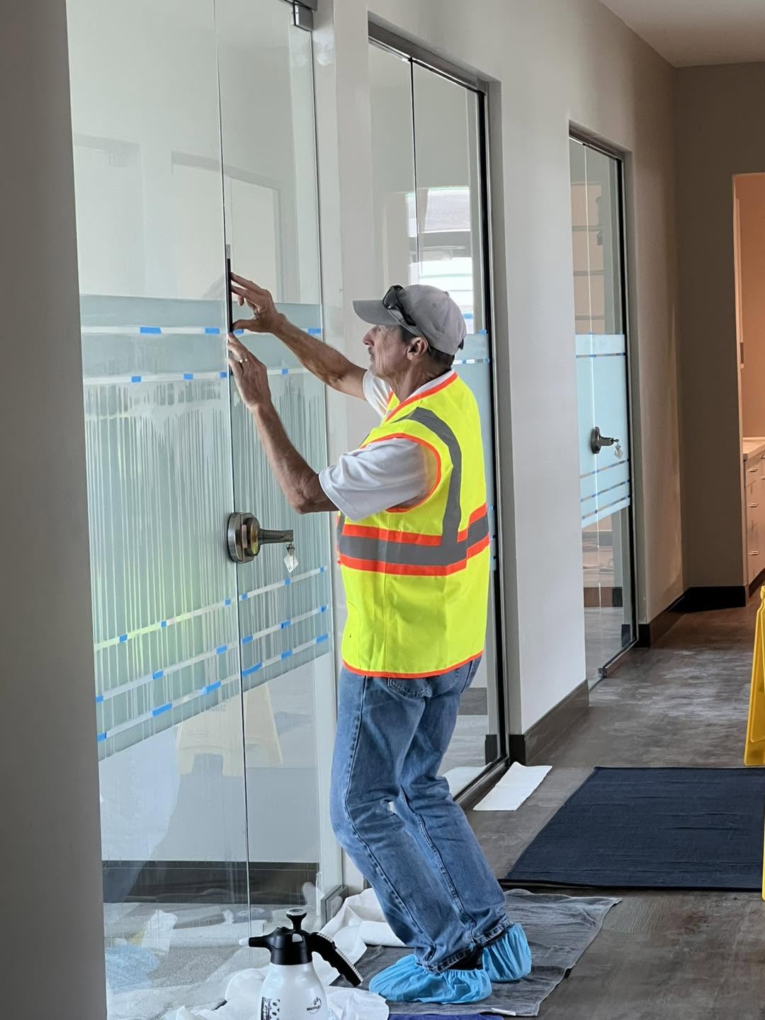 Installer aligning privacy film on an office door at First Tee Naples
